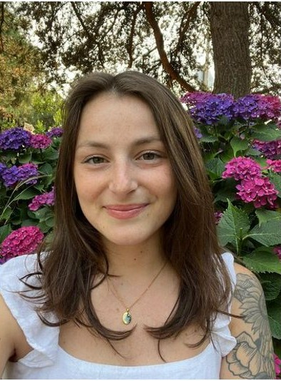 Portrait of Brittney Beadle smiling in front of hydrangeas
